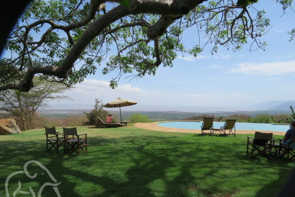 Vanaf een zwembad op een camping in Tanzania kijk je vanaf grote hoogte op Lake Manyara