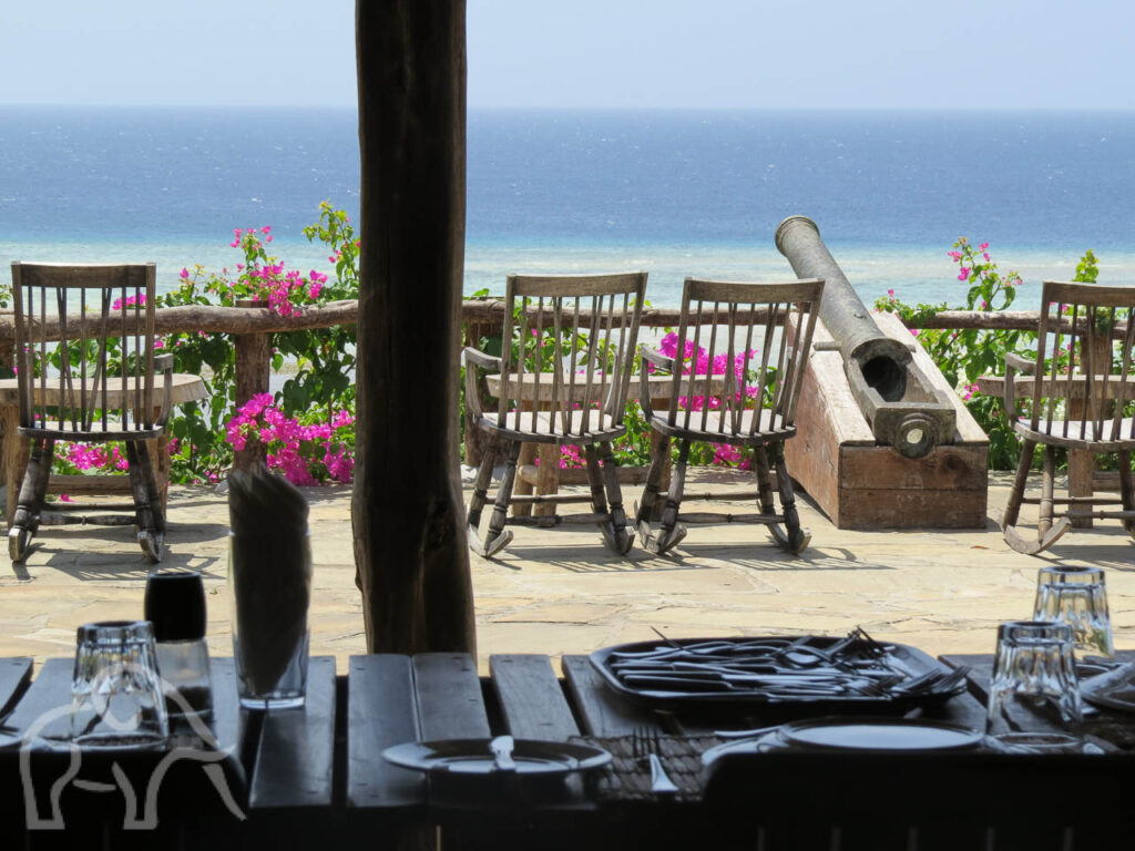 terras van een lodge met stoeltjes en tafeltjes een oud kanon uitkijkend over de indische oceaan