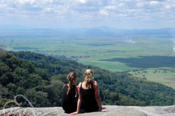 twee jonge meiden zittend op een rots uitkijkend over een vallei bij Udzungwa mountains