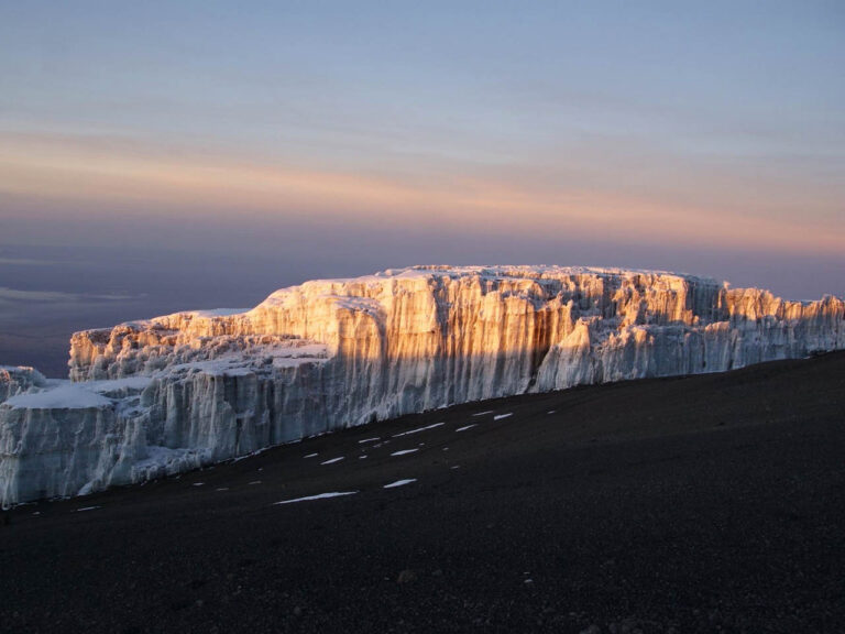 uitzicht van dichtbij van een zonsopkomst op de witte met rood gekleurde sneeuw op de top van de Kilimanjaro