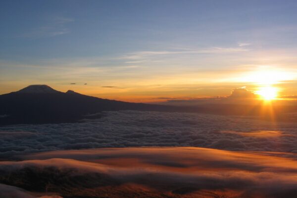 beklimming van mount meru met een opkomende zon boven de wolken op mount menu