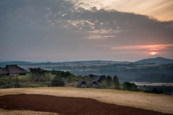 zonsondergang vanaf een heuvel uitkijkend op de lodge van rhotia valley tanzania