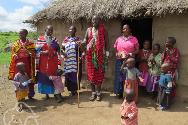 masai familie met ouders en kleine kinderen voor hun boma in de omgeving va de ngorongoro