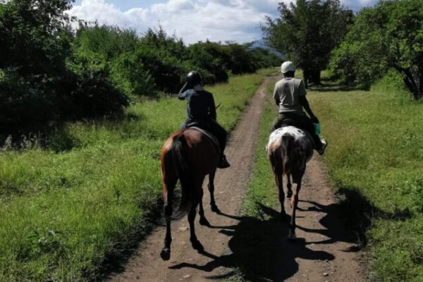 twee mensen op een paard tijdens een safari rondreis in mufindi highlands tanzania activiteit paardrijden