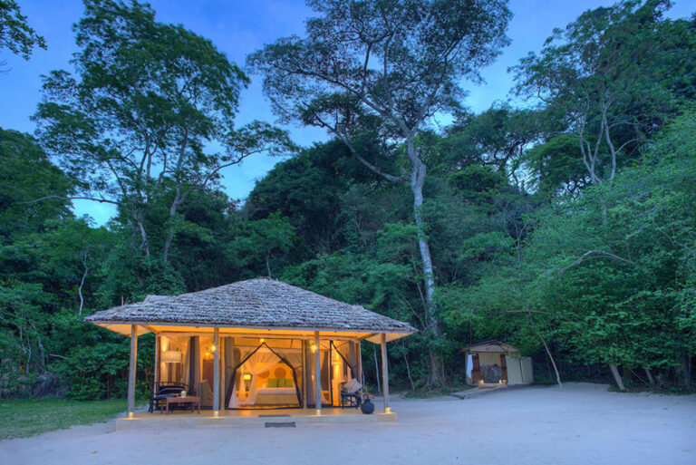 luxe tent met rieten dak verlicht op het strand van lake victoria rebondi tanzania luxe privé safari