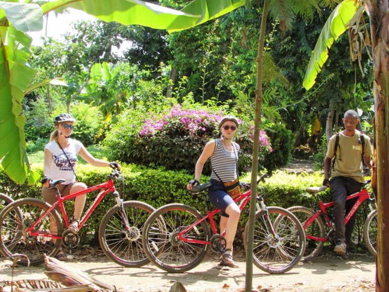twee ouder meiden stilstaand met mountainbike en gids excursie mountainbiken tanzania