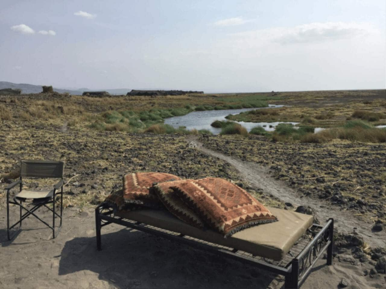 ligbed met kussens met uitzicht over het landschap van Natron Tanzania