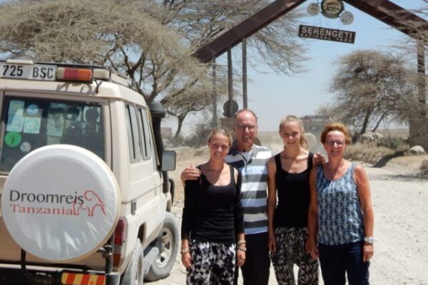 safari auto van droomreis tanzania met daarnaast een familie voor de ingang van de serengeti tanzania