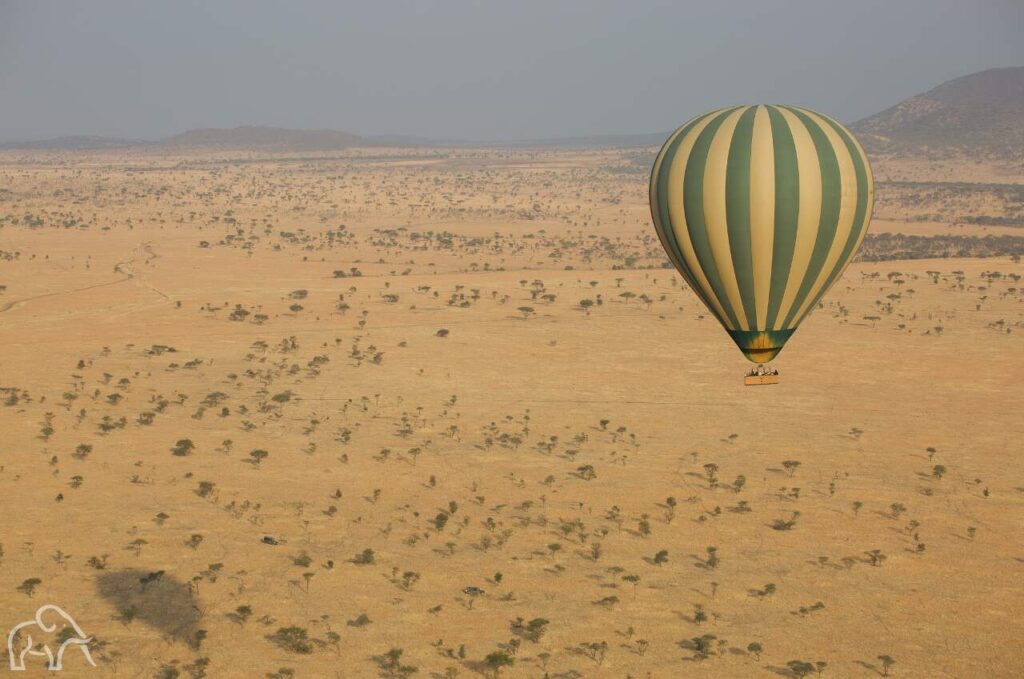 gote luchtballon met geel en groen boven de serengeti genomen vanuit een andere luchtballon