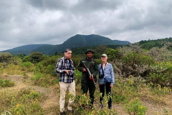 Wandelsafari Tanzania in Arusha National Park. 2 reizigers met een ranger zijn op wandelsafari.