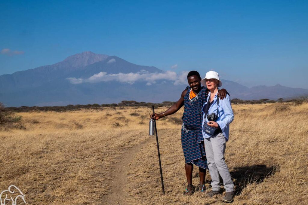 Activiteit wandelen met een Masai. Vrouw en Masai staan in de open vlaktes te poseren. Reisverslag Tanzania