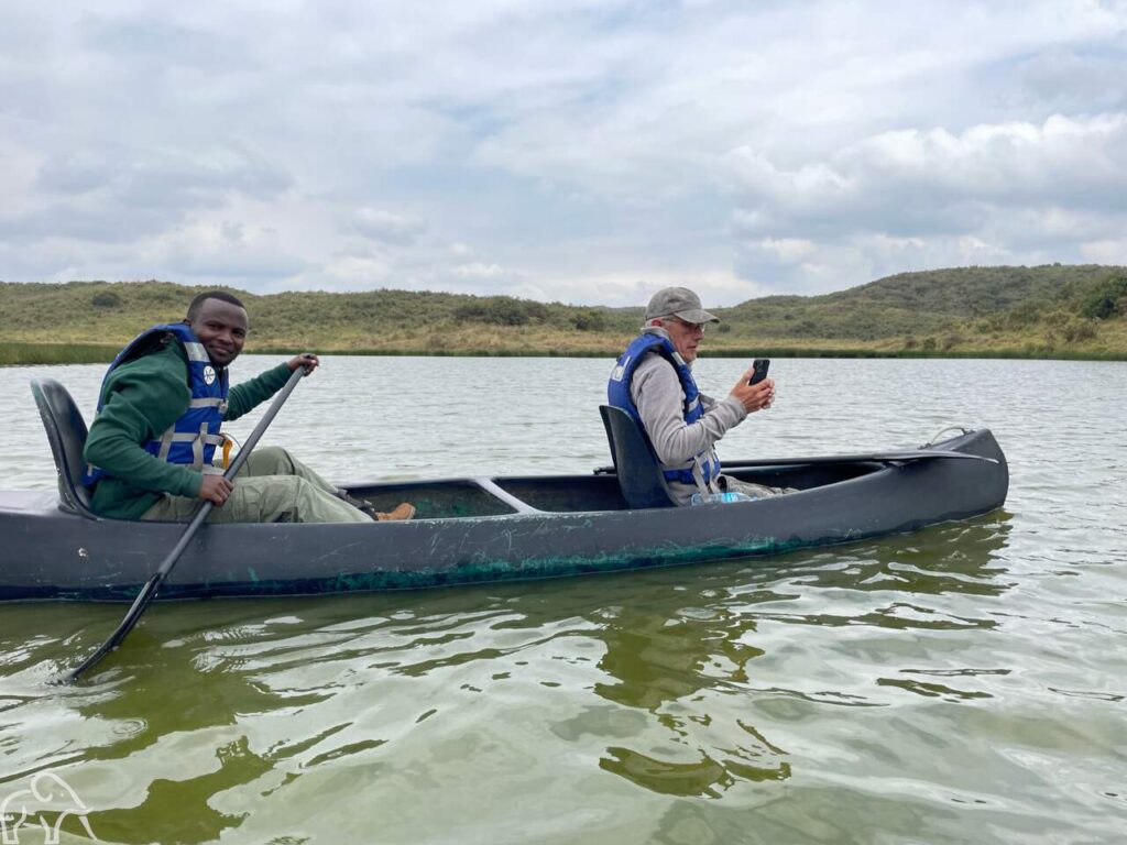 2 mensen in een kano op het kleine Momela meer in Arusha National Park en op de achtergrond heuvel tijdens een inspectiereis van Droomreis Tanzania.