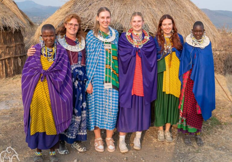 Reizigers in traditionele Masai kleding  poseren samen met de Masai