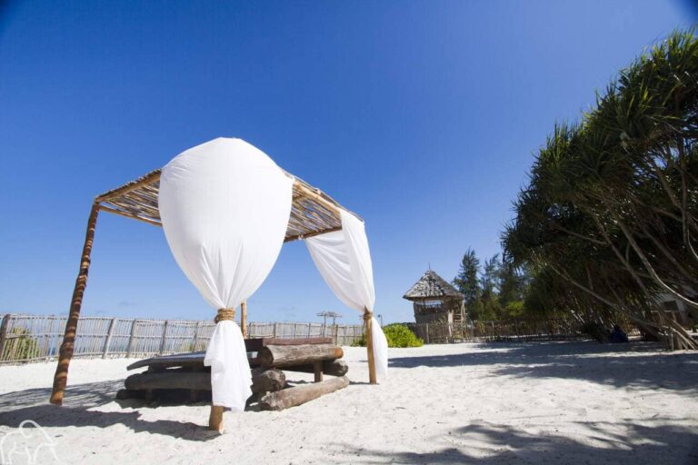 Strandbed met opbollende gordijnen in de wind