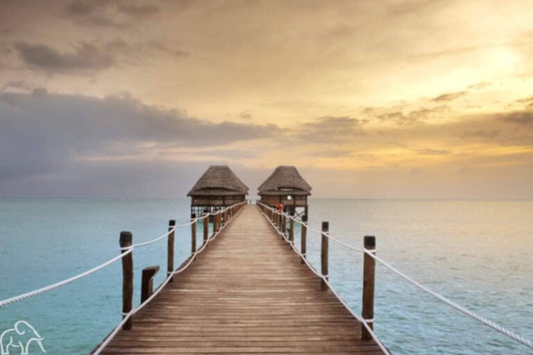 Uitzicht vanaf de houten steiger op twee huisjes in zee