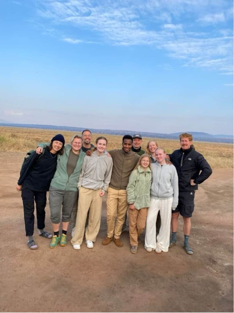 groepsfoto van grote familie met hun gids op de Serengeti