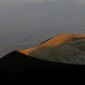 landschap van de crater rim ol doinyo lenga in Tanzania. het bovenstukes stuk is oranje gekleurd door de ondergaande zon
