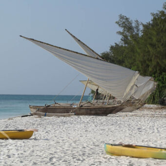 dhows drie vissersboten liggend op het strand met de zeilen geheven aan de kust van de indische oceaan bij Pemba