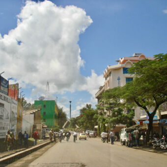 centrum weg in Arusha met links en rechts gebouwen en op de stoep mensen