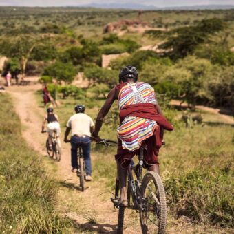 Reizigers met hun gids op fietstocht door het landschap bij de Kilimanjaro