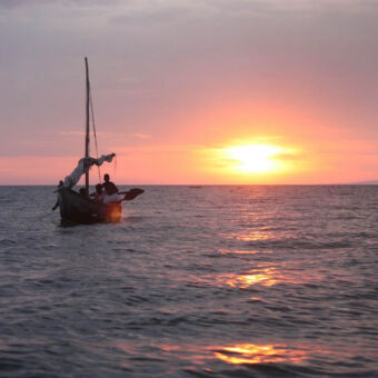 zonsondergang boot met neergelaten zeil bij zonsondergang op lake victoria