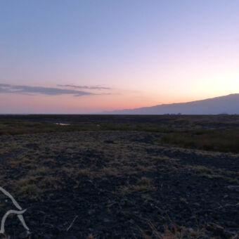 zonsondergang zonsondergang met paars en roodgekleurde luchten en op de voorgrond het maanlandschap bij Lake Natron