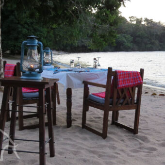 candlelight dinner op het strand een gedekte tafel met stoelen klaar voor een romantisch diner aan het het lake victoria