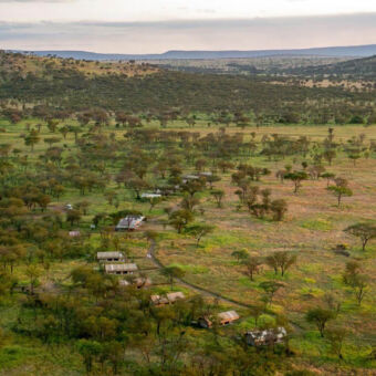 vanuit de lucht vanuit de lucht een overzicht van een tented kamp met tenten in een halve cirkel staand in de vlaktes van de serengeti