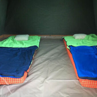 binnenkant tent binnenkant van een koepeltentje met twee matrassen met daarop slaapzakken en kussens