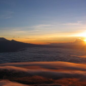 zonsopkomst Mount Meru beklimming van mount meru met een opkomende zon boven de wolken op mount menu