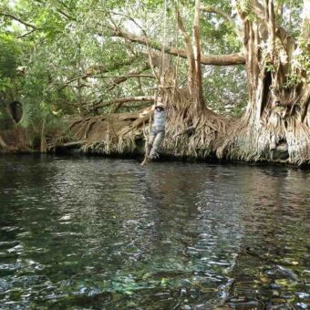 slingeren aan het touw vrouw slingert aan een touw over het water bij Chemka hotspings tanzania