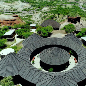 Olduvai Gorge museum vanuit de lucht het olduval gorge museum in tanzania een gebouw met zwart dak in een cirkel waarin het middel nog een rond gebouw staat