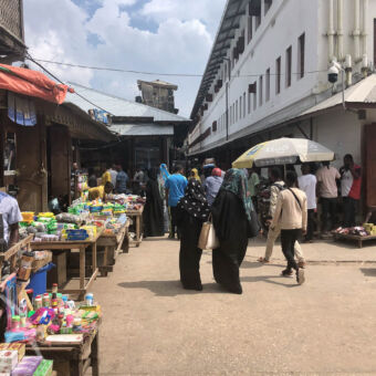 bedrijvig Stone Town wandelende mensen sommige met lange gewaden opeen markt in stone town tijdens een wandeling zanzibar