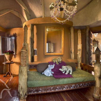 bijzondere architectuur zeer luxe kamer met een heel groot bed en allerlei houtsnijwerk met meerdere ruimtes redelijk traditioneel in de buur van de ngorongoro tanzania