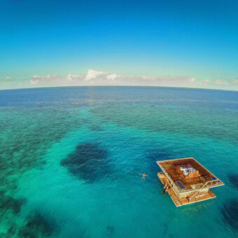 onderwaterhotel azuurblauwe oceaan met een persoon die zwemt bij de onderwaterkamer van manta resort pemba tanzania