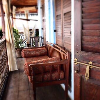 veranda veranda van een kamer met een traditioneel houten bank met rode kussens op zanzibar tanzania