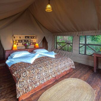 ruime tenten twee persoons canvas tent op palen met mooi opgemaakt bed van hout