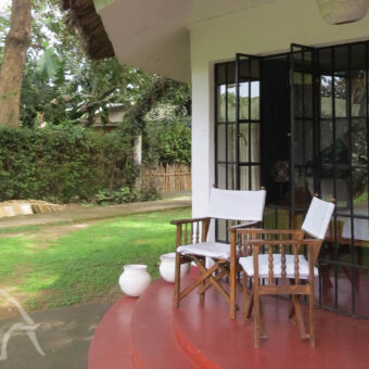 Ilboru veranda met twee stoeltjes en uitzicht op de tuin bij Ilboru Safari lodge Arusha tanzania