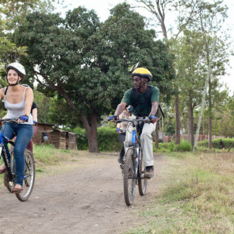 ontspannen tocht meisje en man met helm aan het mountainbiken over een onverharde weg