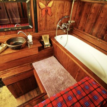 bad nauwelijks te herkennen maar in de achterbak van een landrover gemaakte badkamer met bad ,wc en wastafel de badkamer is onderdeel van een zeer speciale accommodatie met de naam bush rover in de serengeti