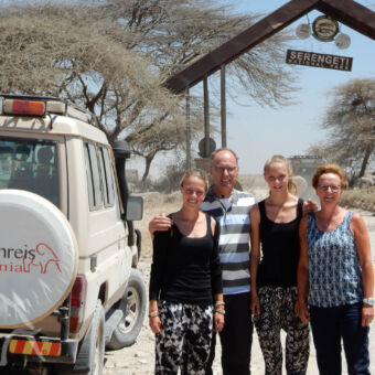 parkentree Serengeti safari auto van droomreis tanzania met daarnaast een familie voor de ingang van de serengeti tanzania