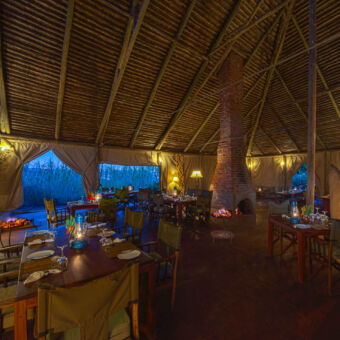 restaurant restaurant van rhotia valley vierkant met hoog rieten puntdak en een openbaar met vuur in het midden verder gedekte tafels met sfeer verlichting