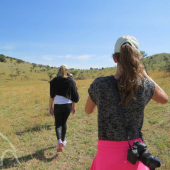 opstellen in een lijn twee jonge meiden lopend over de serengeti tijdens een wandelsafari