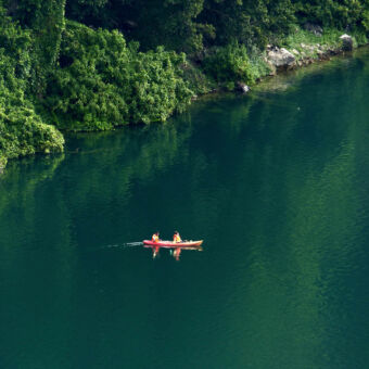 kayakken in het groen van bovenaf een uitzicht op het groene meer chala met een kayak en twee mensen
