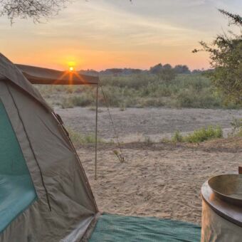 Kichaka Expeditions zonsondergang gezien vanachter de tenten bij de ruaha rivier tanzania