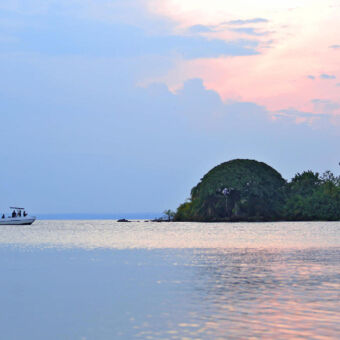 zonsondergang bij Lake Victoria zonsondergang op het Lake Victoria met een bootje en de kust op de achtergrond bird watching safari tanzania