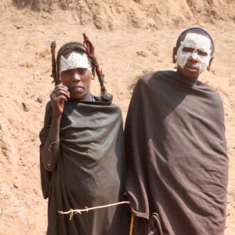 jonge Masai twee masai jongens met witte traditie gezicht maskers en zwarte kleden cultuur activiteit tanzania