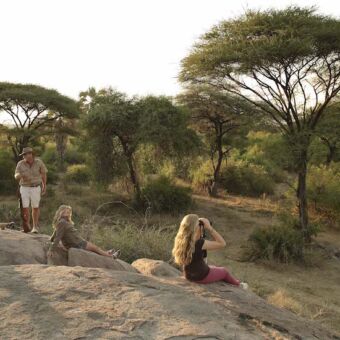 Ruaha groepje koffie drinkende mensen zittend op een rots tijdens een wandelsafari in ruaha met molly kichaka expeditions tanzania