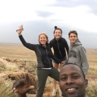 reiservaring zwaaiende moeder met tieners op de vlaktes van de serengeti tanzania