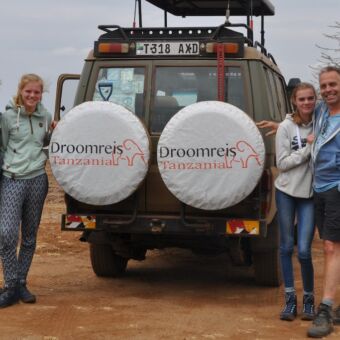 familie met 2 kinderen bij de stoere safari auto van droomreis tanzania tijdens privé safari